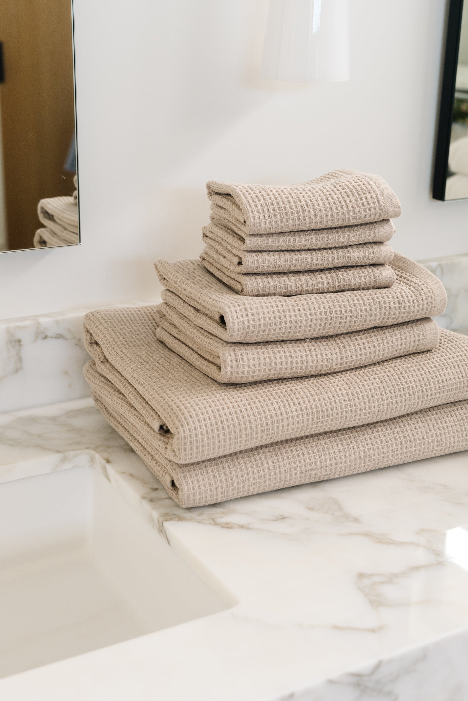 Waffle Bath Towel Set in the color Sand. Photo of Sand Waffle Bath Towel Set taken resting on a marble counter top. 