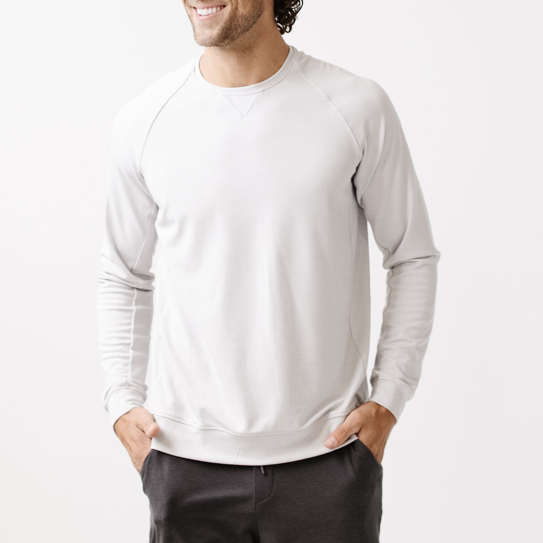 Light Grey/Charcoal Men's Bamboo Jogger Set. There is a man wearing the jogger set. He is standing in a well lit room in a home.