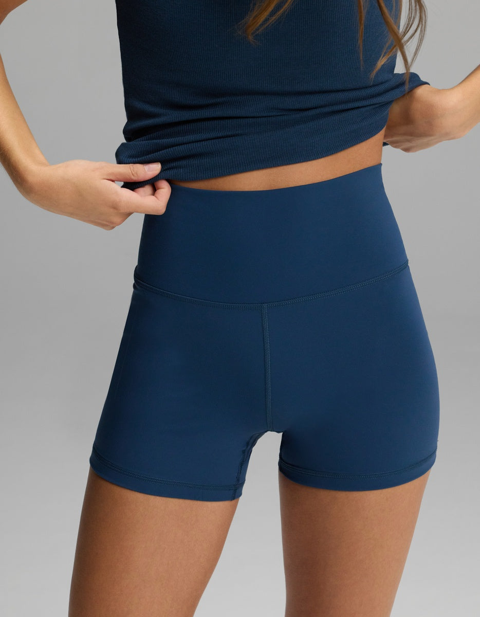 A person wearing dark blue, high-waisted Women’s Liv Biker Short 4″ by Cozy Earth.