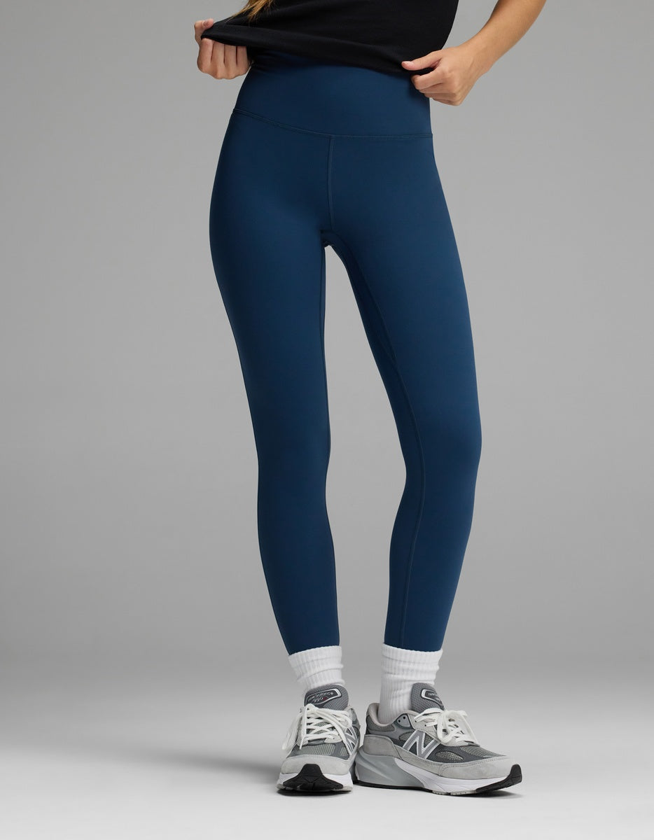 Women’s Liv Leggings in navy blue worn with white socks and grey sneakers.|Color:Obsidian