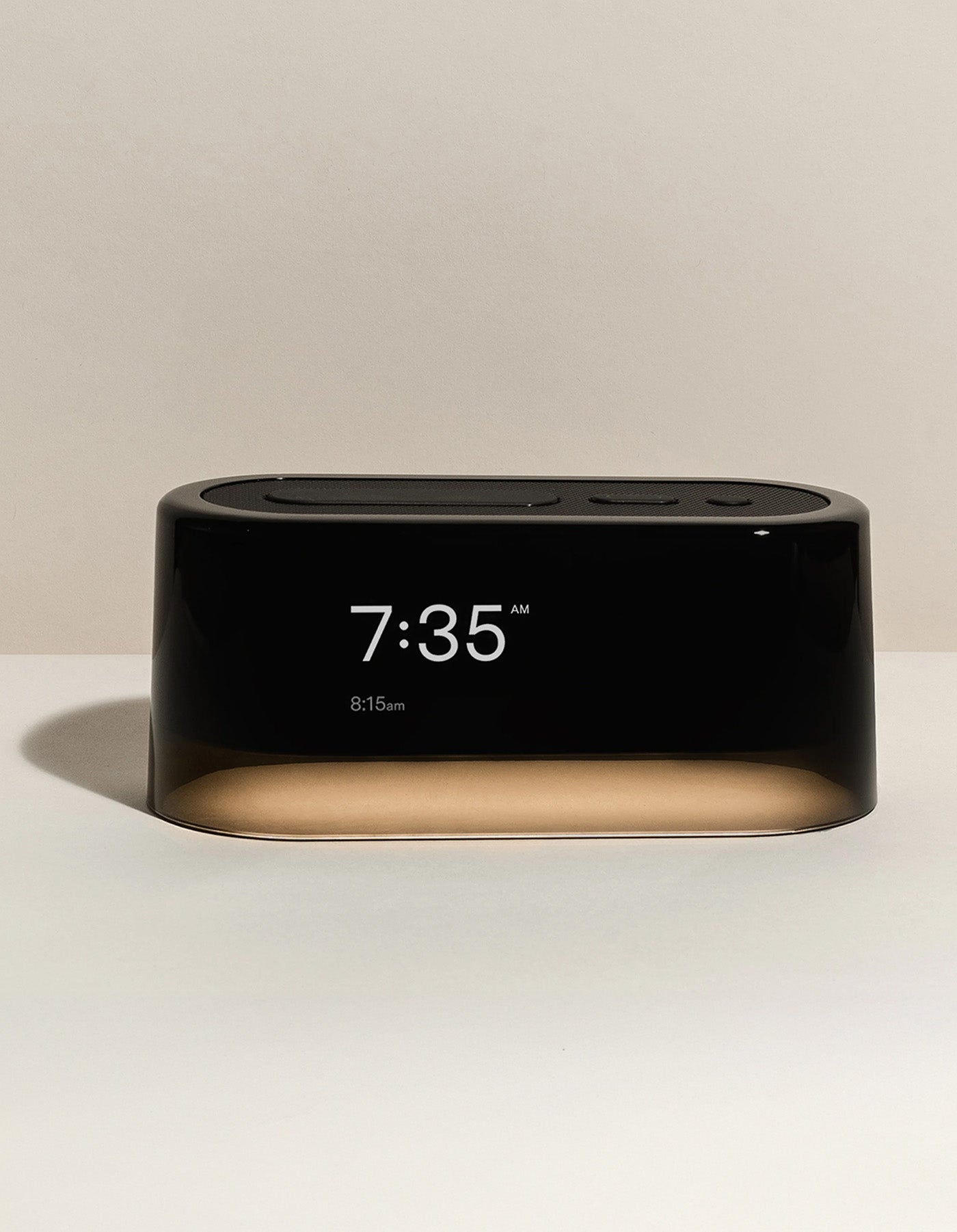 The Cozy Earth Bamboo Sheet Set x Loftie Clock features a modern black digital alarm clock showing 7:35 AM, with an alarm set for 8:15 AM, against a neutral beige background.