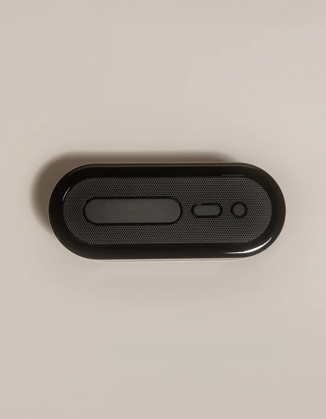 The Bamboo Sheet Set x Loftie Clock by Cozy Earth is displayed on a plain light background, combining sleek design with functionality in a modern black form featuring rounded edges and distinct buttons.