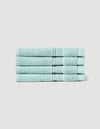 Four Luxe Washcloths by Cozy Earth, neatly folded in light blue, are stacked uniformly against a plain light gray background.
