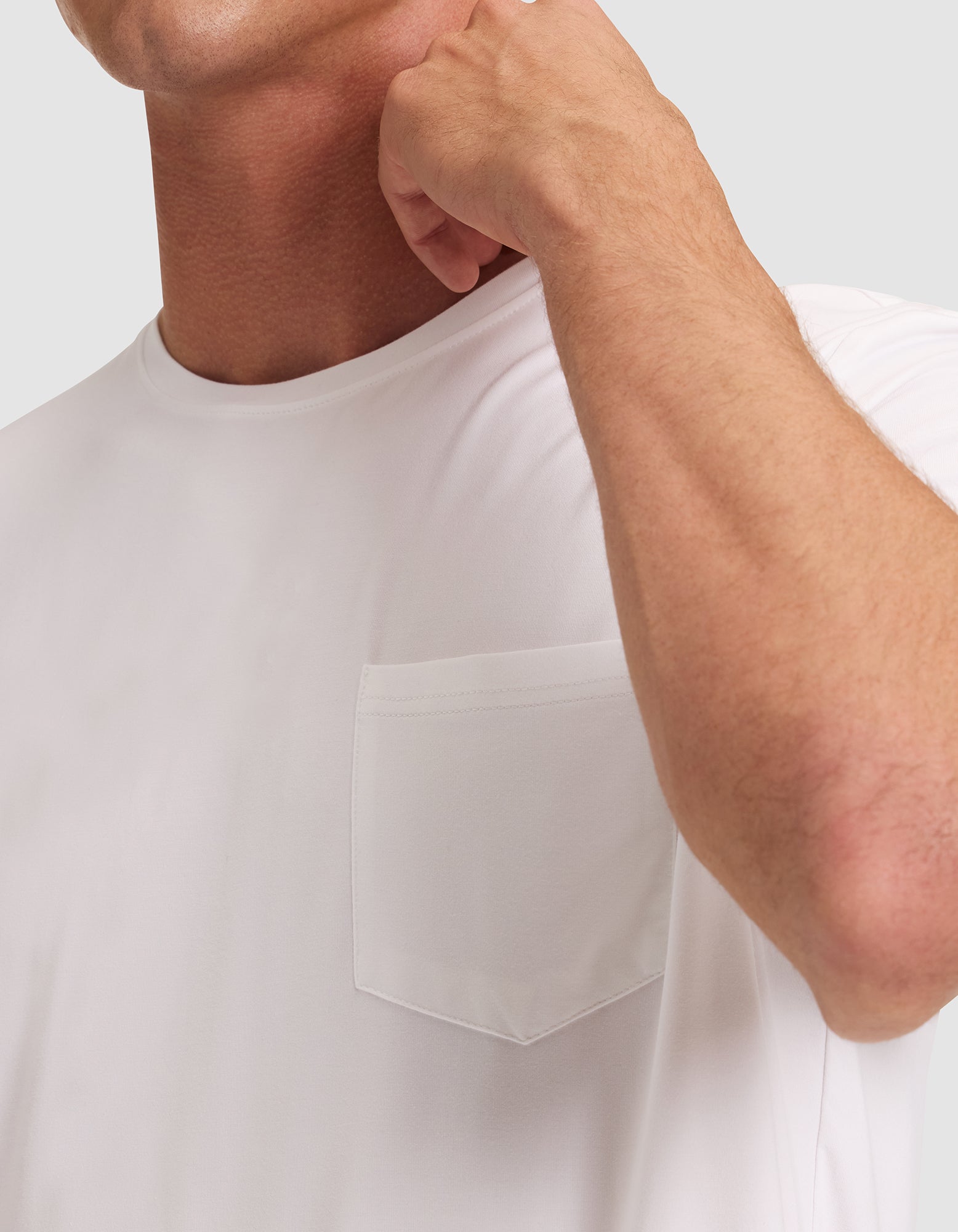 A man wearing the Cozy Earth Men's Bamboo Stretch-Knit Lounge Tee, which features a chest pocket; only his lower face and upper torso are shown as he raises his hand near his face. 