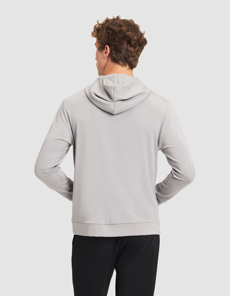 A man with short curly hair is seen from behind in a Cozy Earth Men's Brushed Bamboo Hoodie, light gray, paired with black pants against a plain light background.