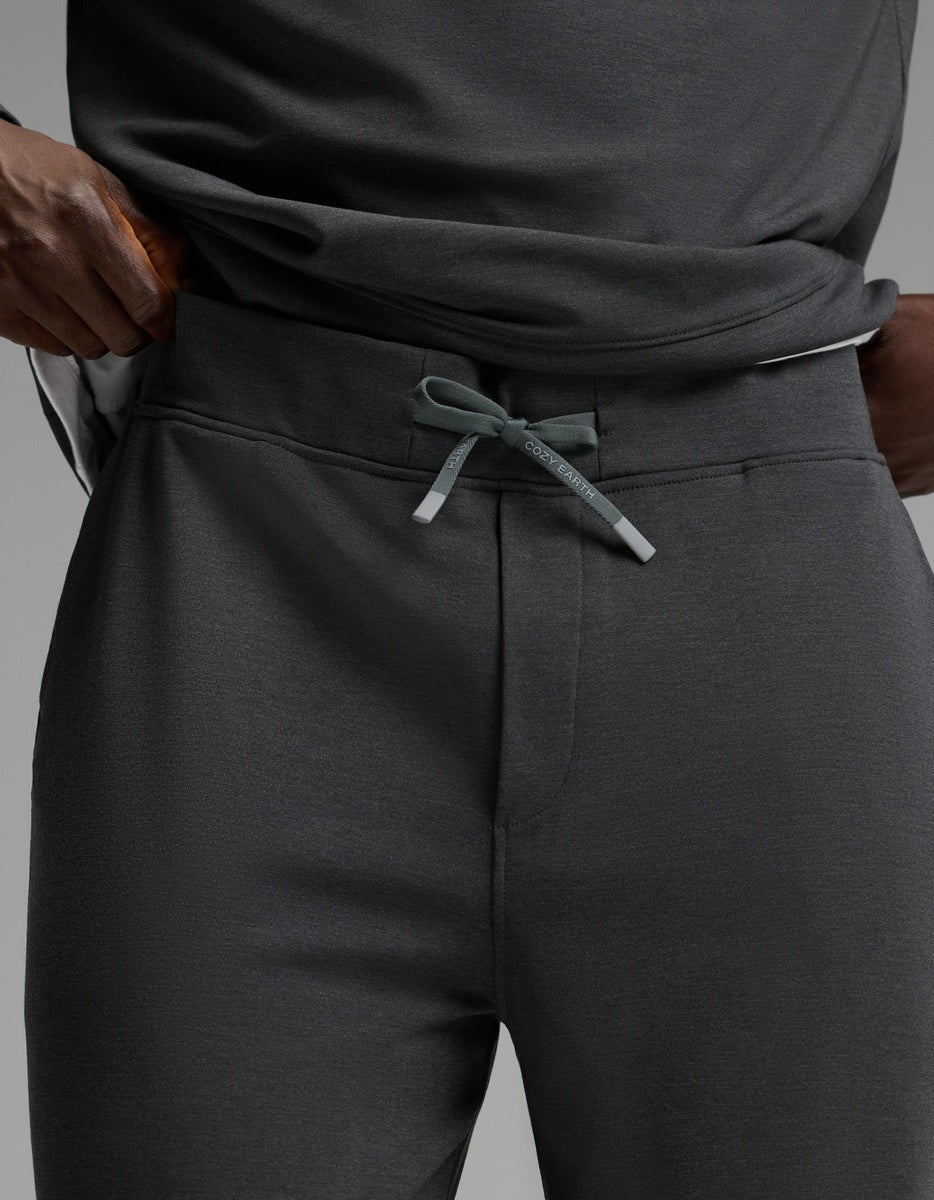 A person wearing Cozy Earth Men’s Brushed Bamboo Joggers in dark gray with a drawstring, paired with a matching shirt, hands resting on their hips.