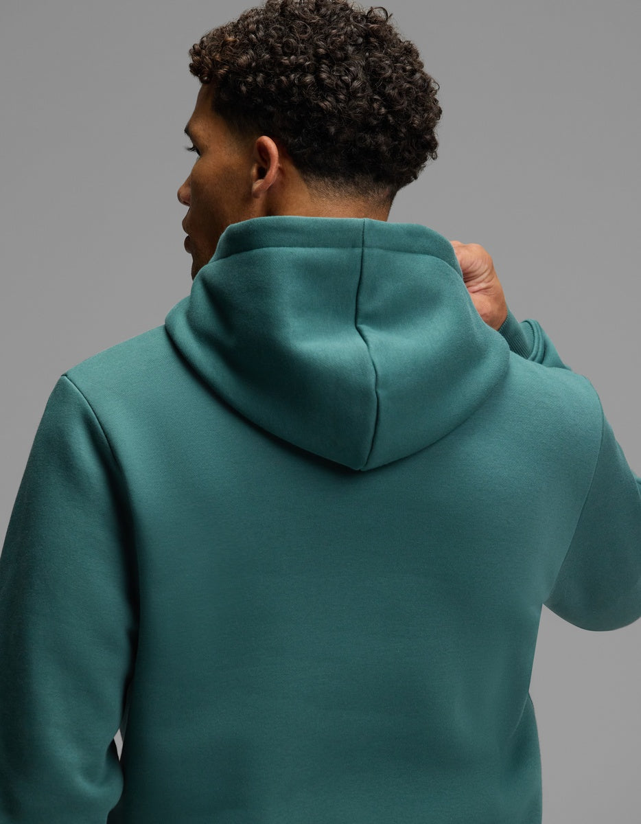 A person seen from behind, wearing a teal Cozy Earth Men’s Cityscape Hoodie.