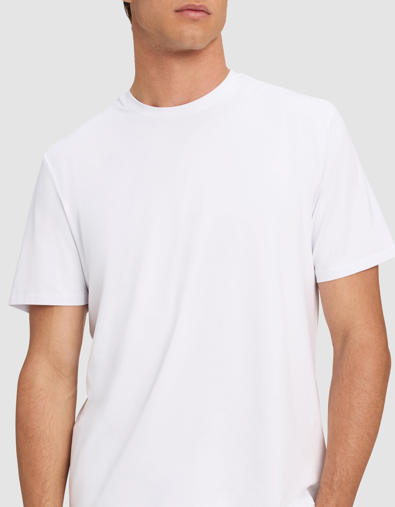 A man wears the Cozy Earth Men's First Layer Pajama Short Sleeve Tee, shown from shoulders to waist against a light gray background. His face is partially out of frame.