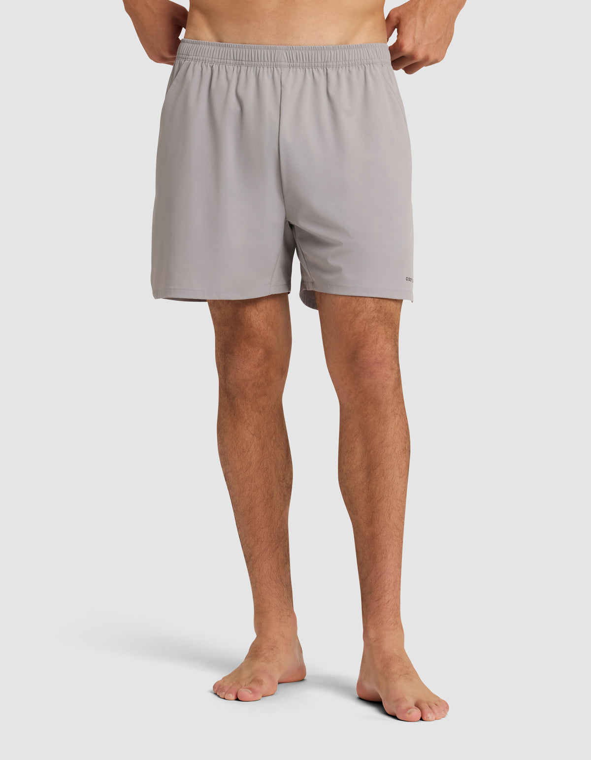 Man shown from waist down wearing gray Cozy Earth Performance Sleep Shorts shorts on a light grey background