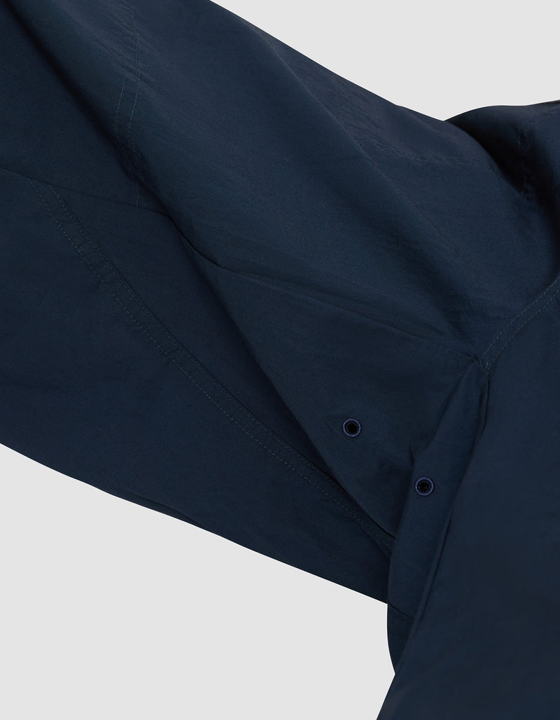 Close-up of the underarm area of the Cozy Earth Men's Sleep Pant in dark blue, showing two small ventilation eyelets and visible stitching that highlight the fabric and construction details.