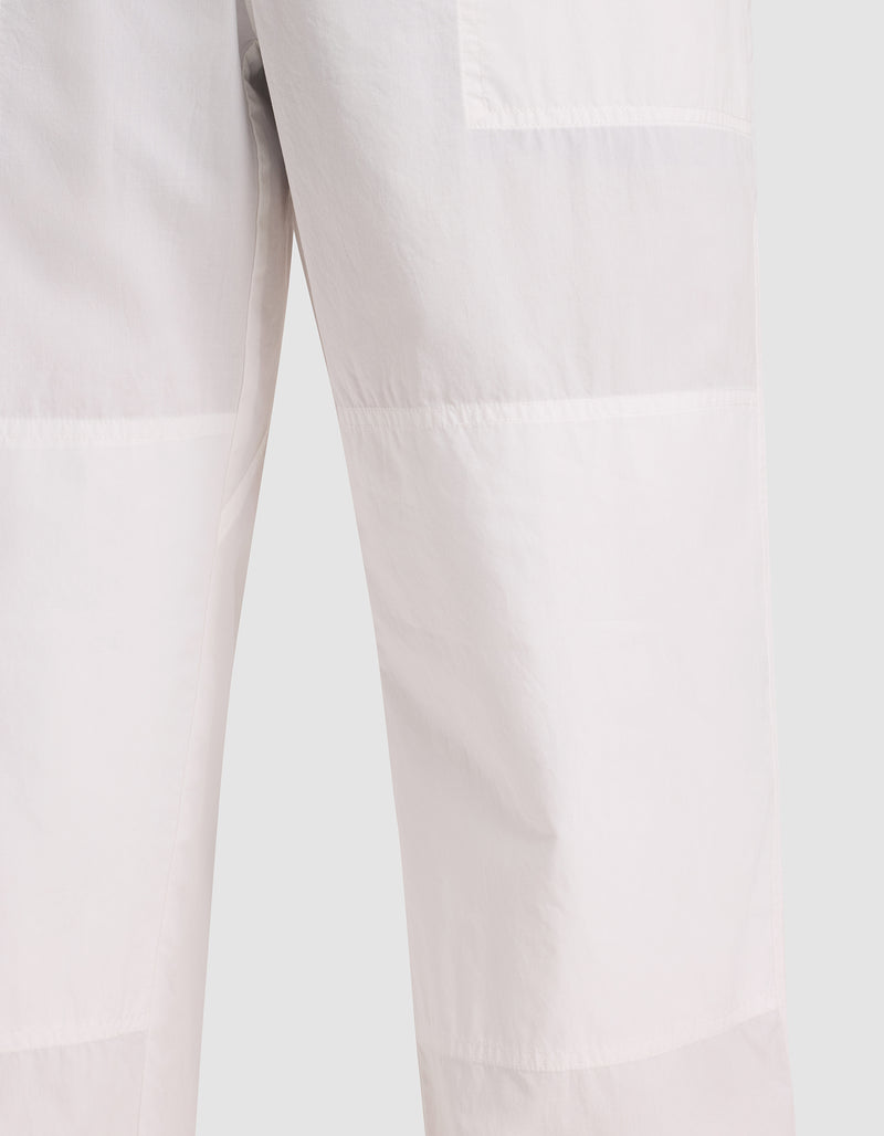 Close-up of Cozy Earth Men's Sleep Pant in a light color, featuring visible stitching and panel detailing, shown against a plain background.