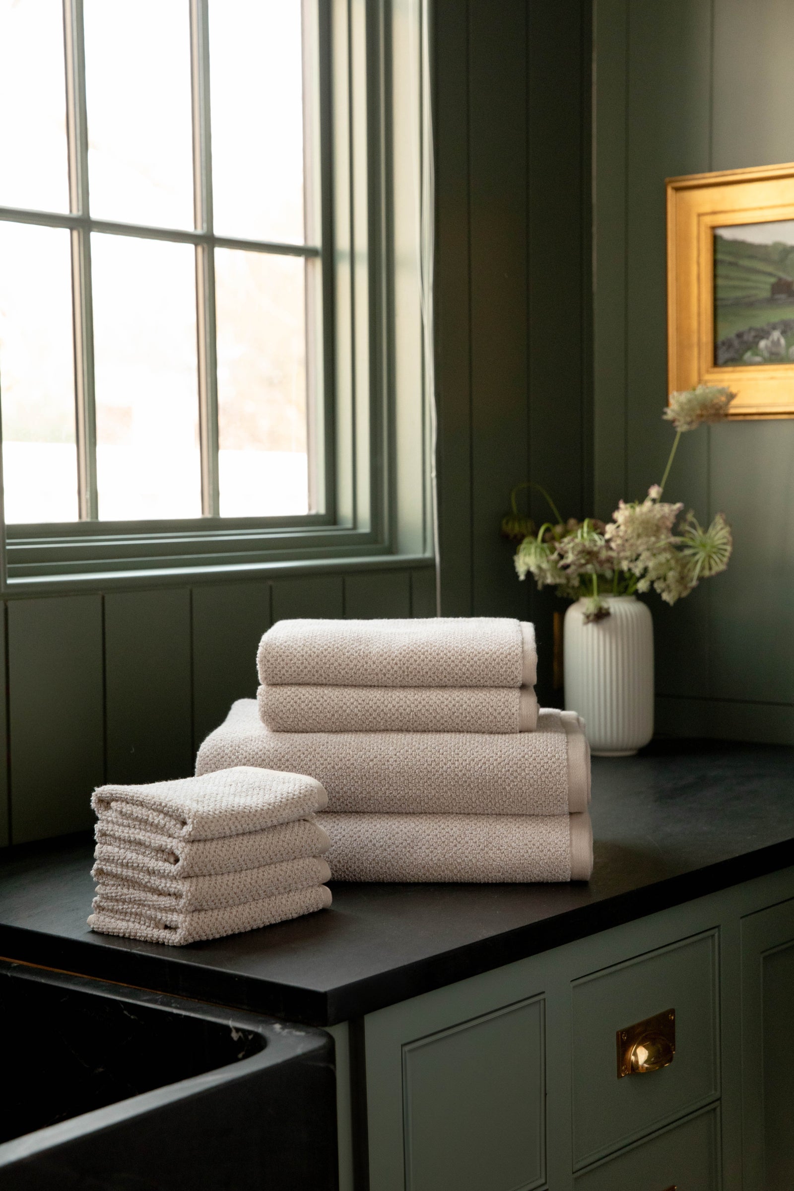 Nantucket Bath Towel Set in the color Heathered Sand. Photo of Nantucket Bath Towel Set taken with the Heathered Sand Bundle resting on a bathroom countertop. 