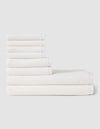 The Cozy Earth Nantucket Bath Towel Set features seven white textured towels—three large and four small—neatly stacked in two rows on a light gray background, showcasing their soft, plush feel.|Color:White