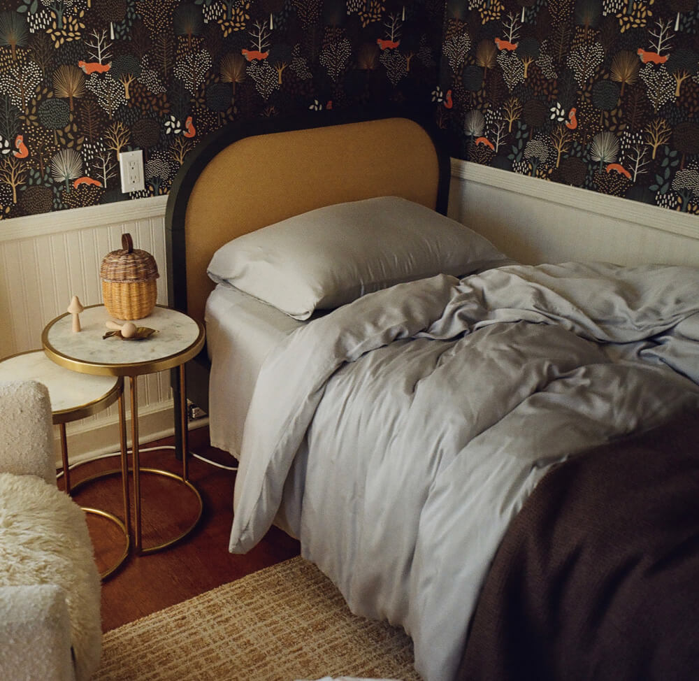 Bedroom with a bed, side table, and decorative wall paper
