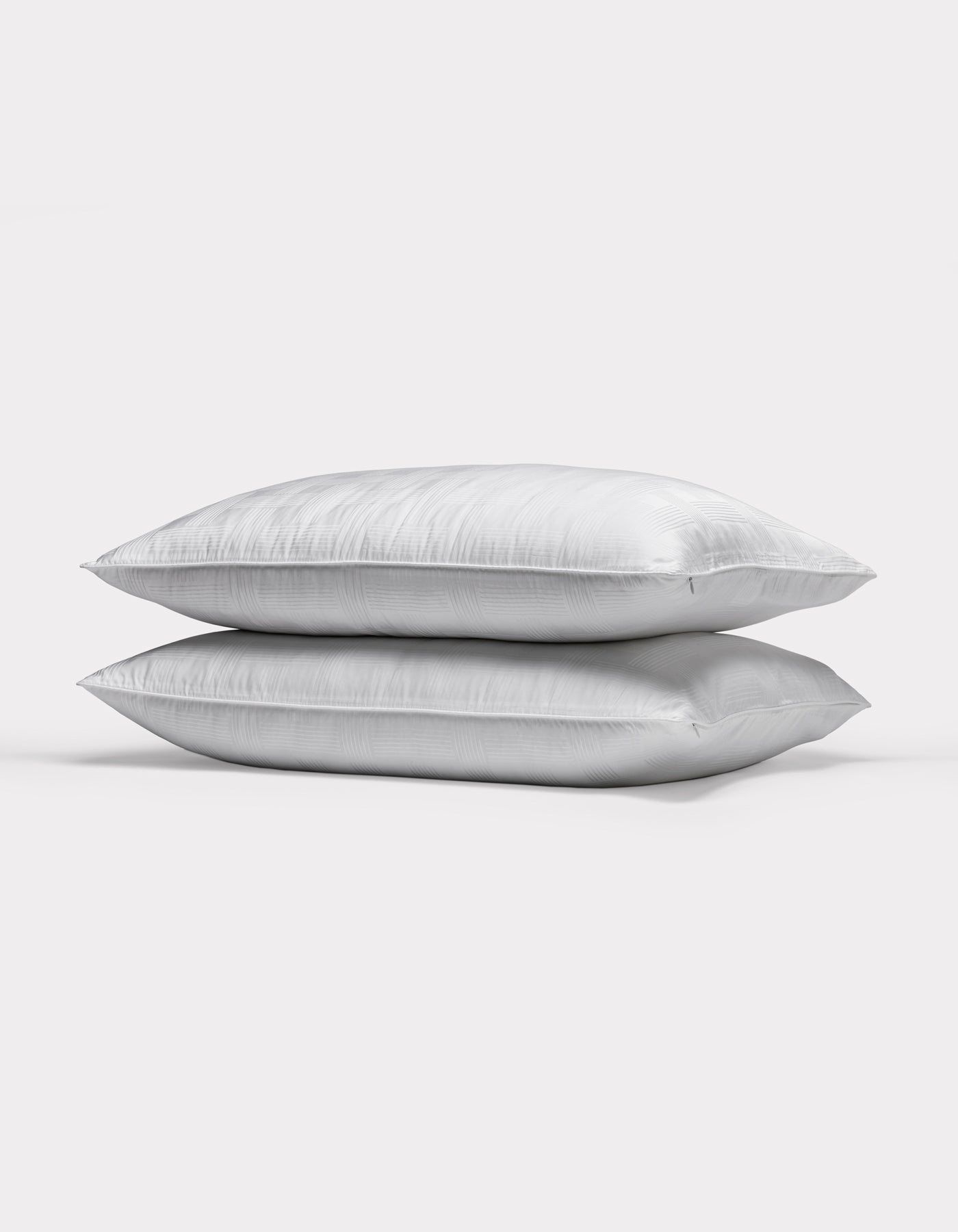 Two Cozy Earth Pillow Protectors are stacked together against a plain, light gray background.