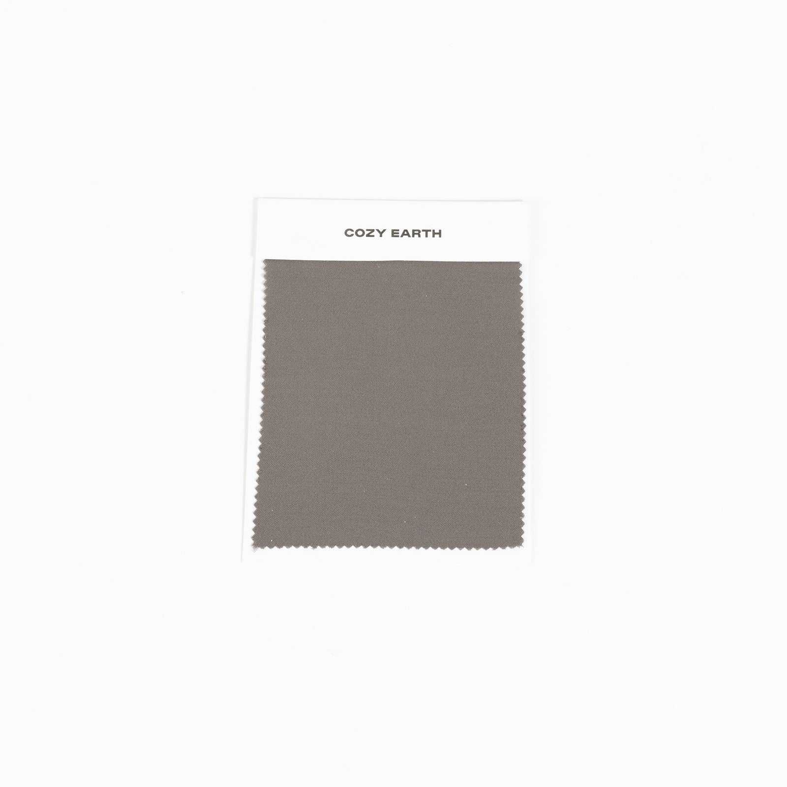 A fabric swatch labeled "Bamboo Sheet Swatch" by Cozy Earth is displayed against a plain white background. The fabric is a solid gray color. 