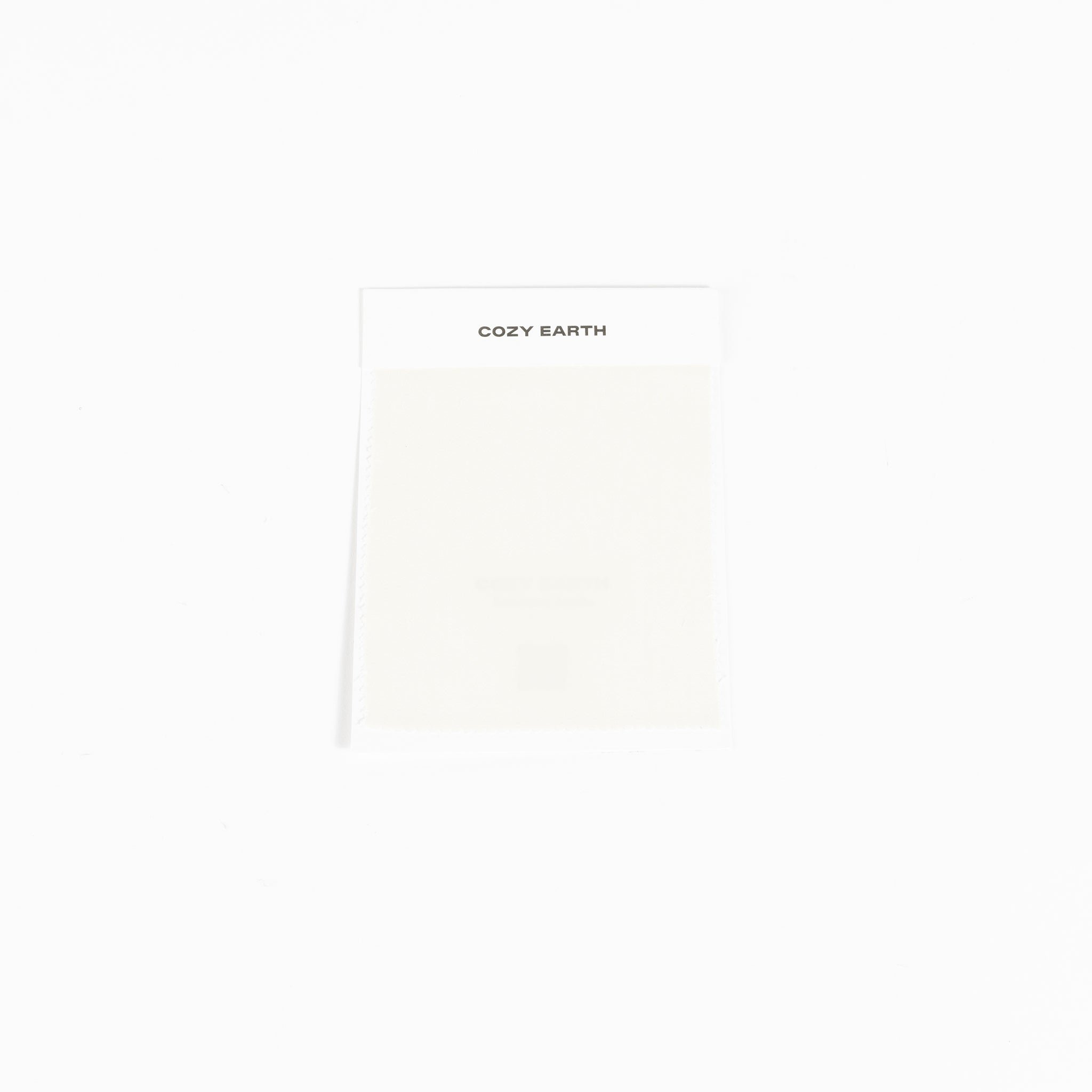 A compact rectangular package set against a white background features the "Cozy Earth" label at the top and appears to contain a light-colored item, specifically a Bamboo Sheet Swatch. |Color:Creme