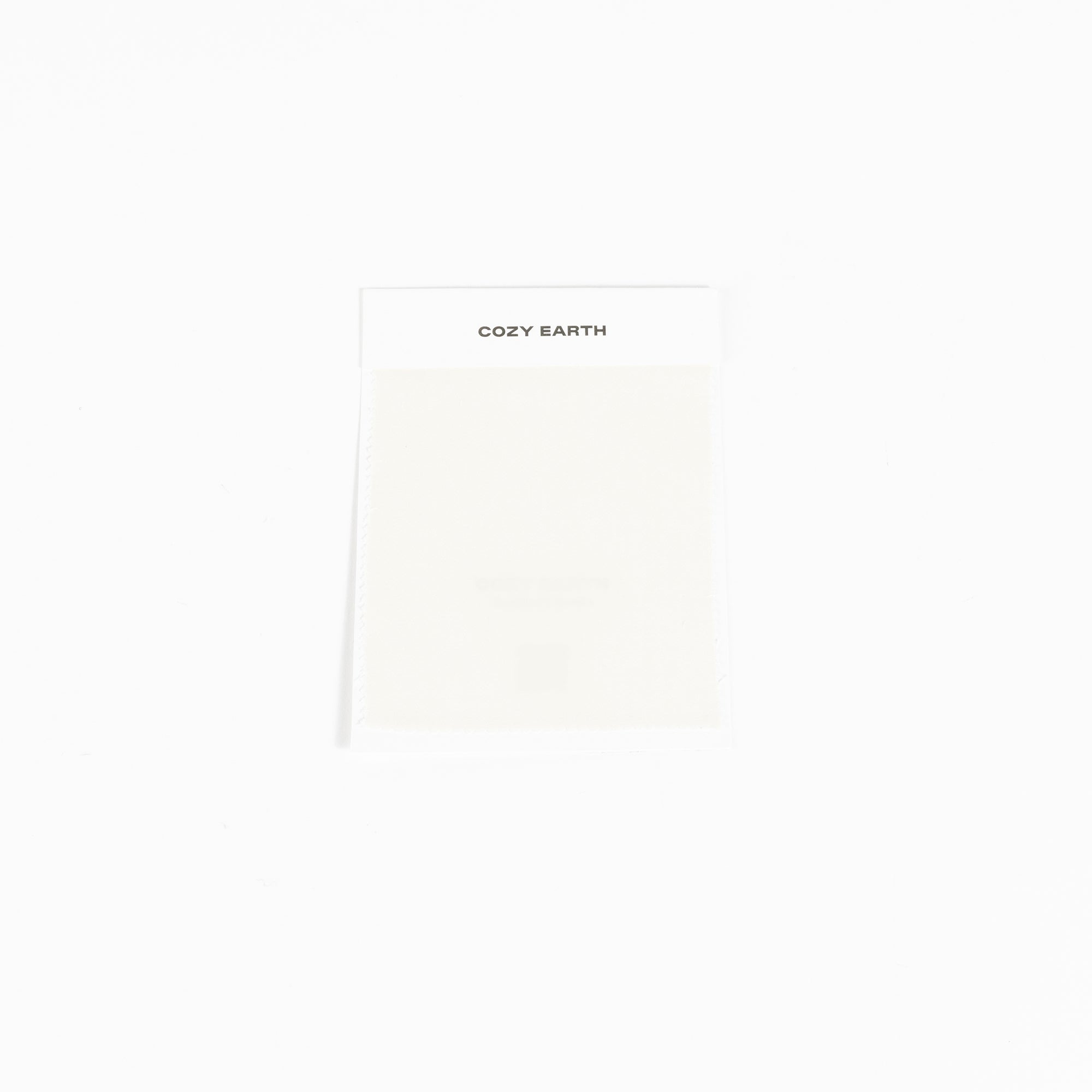 A compact rectangular package set against a white background features the "Cozy Earth" label at the top and appears to contain a light-colored item, specifically a Bamboo Sheet Swatch. 