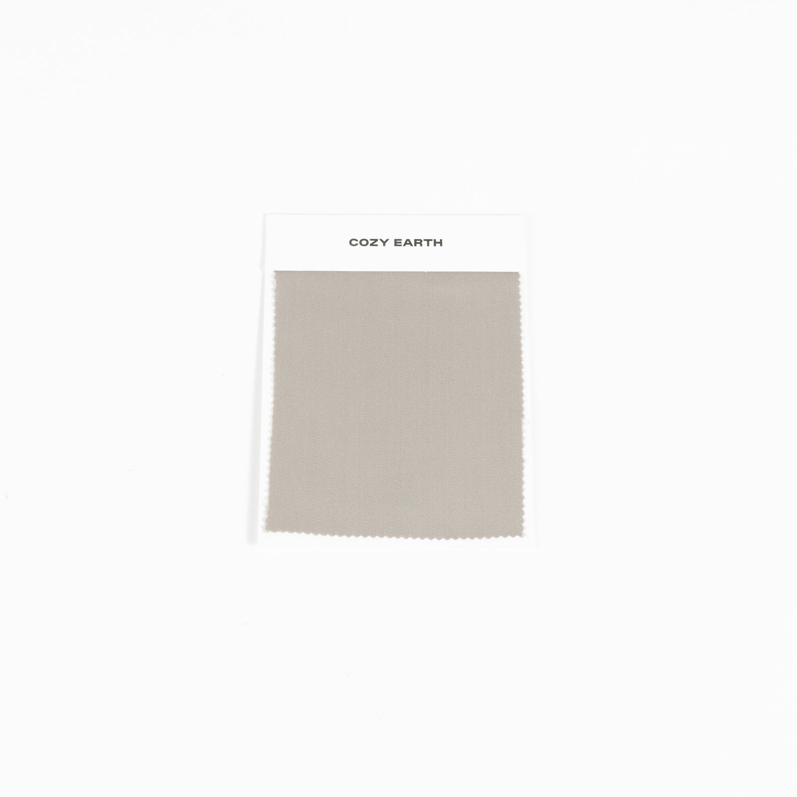 A swatch from the Bamboo Sheet collection by Cozy Earth is shown against a white background. It features a white label at the top with the brand name, "COZY EARTH. 