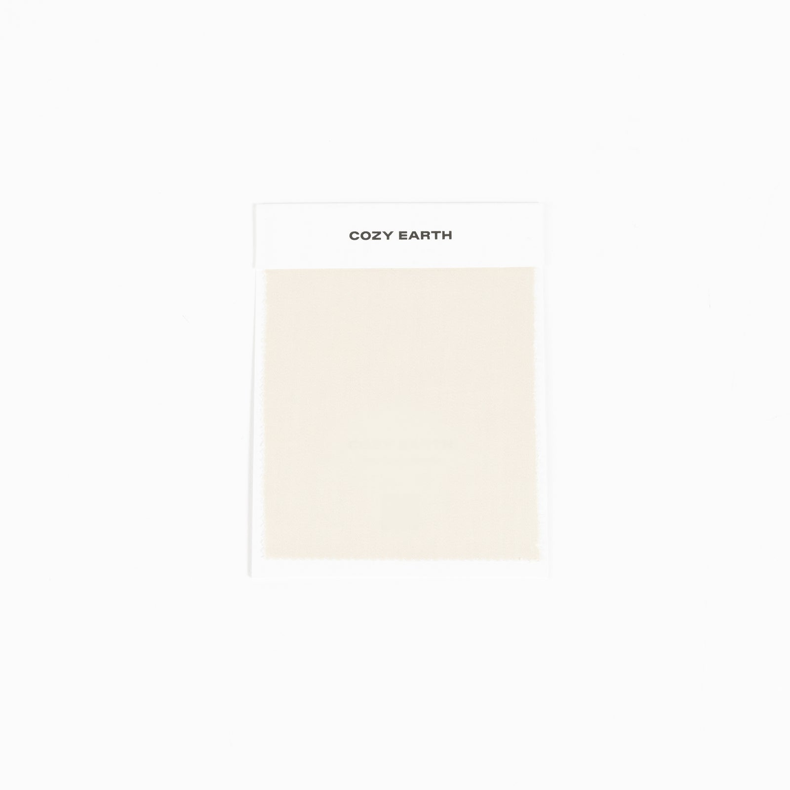 A white card labeled "Bamboo Sheet Swatch" by Cozy Earth featuring a sample of light beige fabric. 