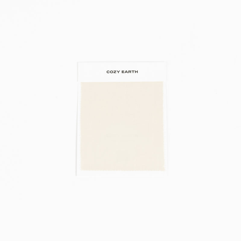 A white card labeled "Bamboo Sheet Swatch" by Cozy Earth featuring a sample of light beige fabric.