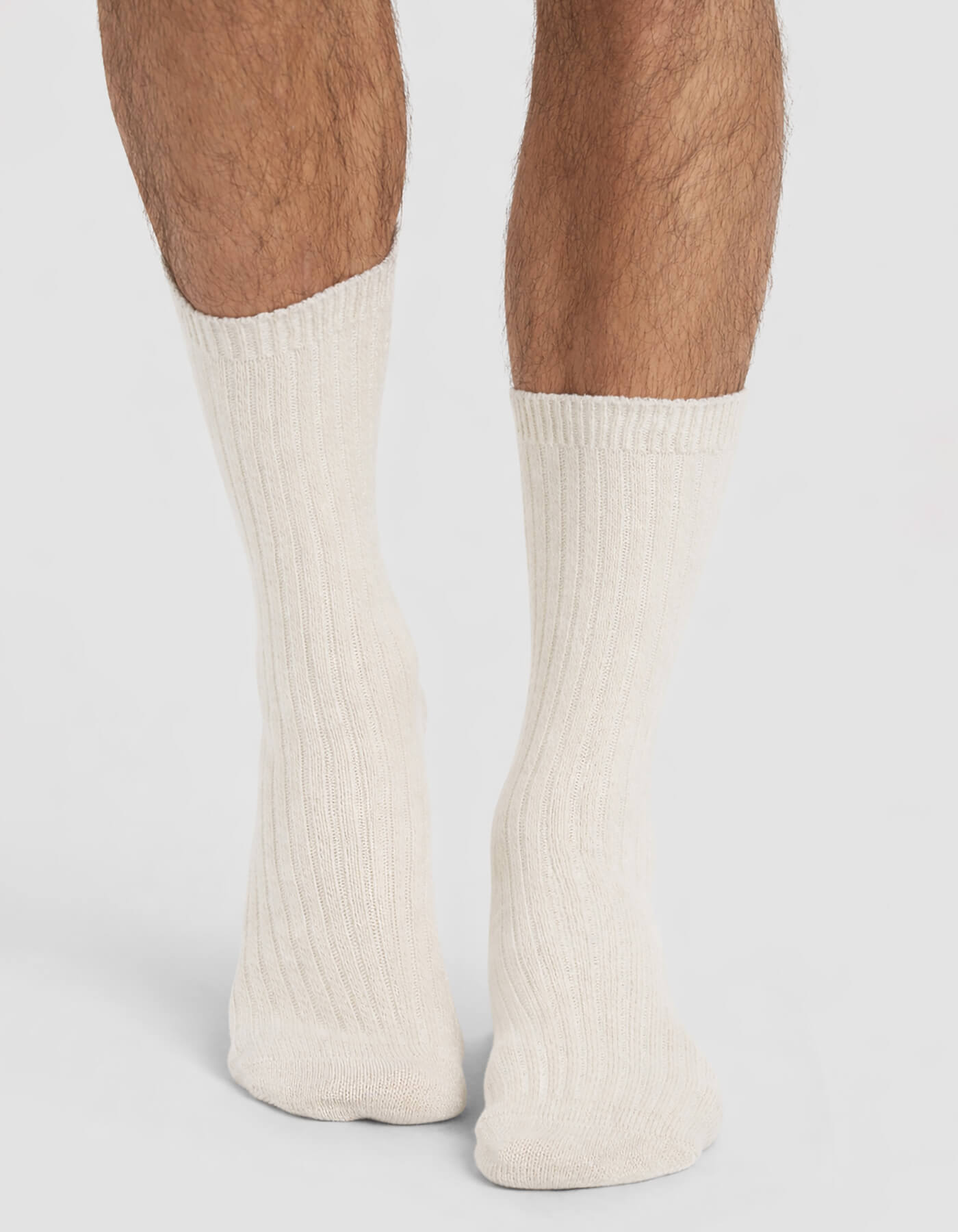 A person wearing Cozy Earth Men's Plush Lounge Quarter Socks, standing with their feet close together on a plain background.