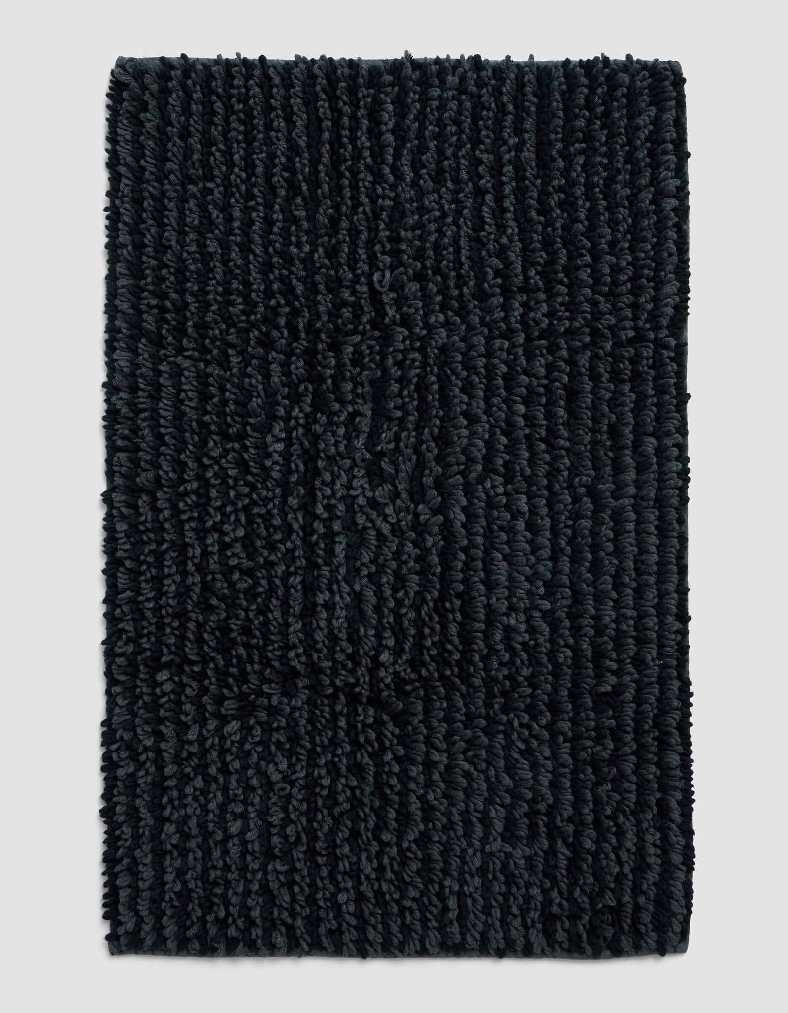 The Cozy Earth Plush Loop Bath Mat, rectangular and dark gray with thick textured fibers, is displayed on a plain light gray background.