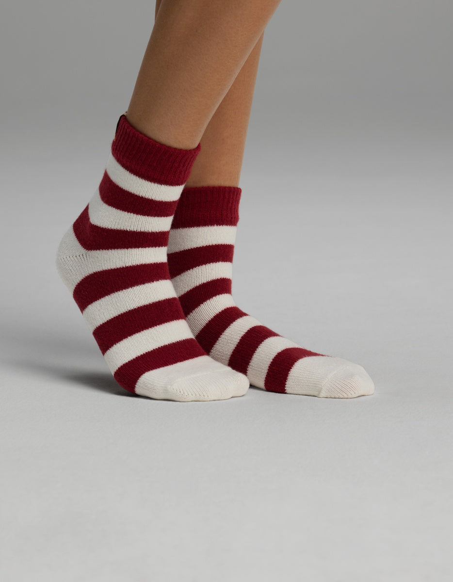 A pair of Women’s Plush Lounge Quarter Socks with red and white horizontal stripes.