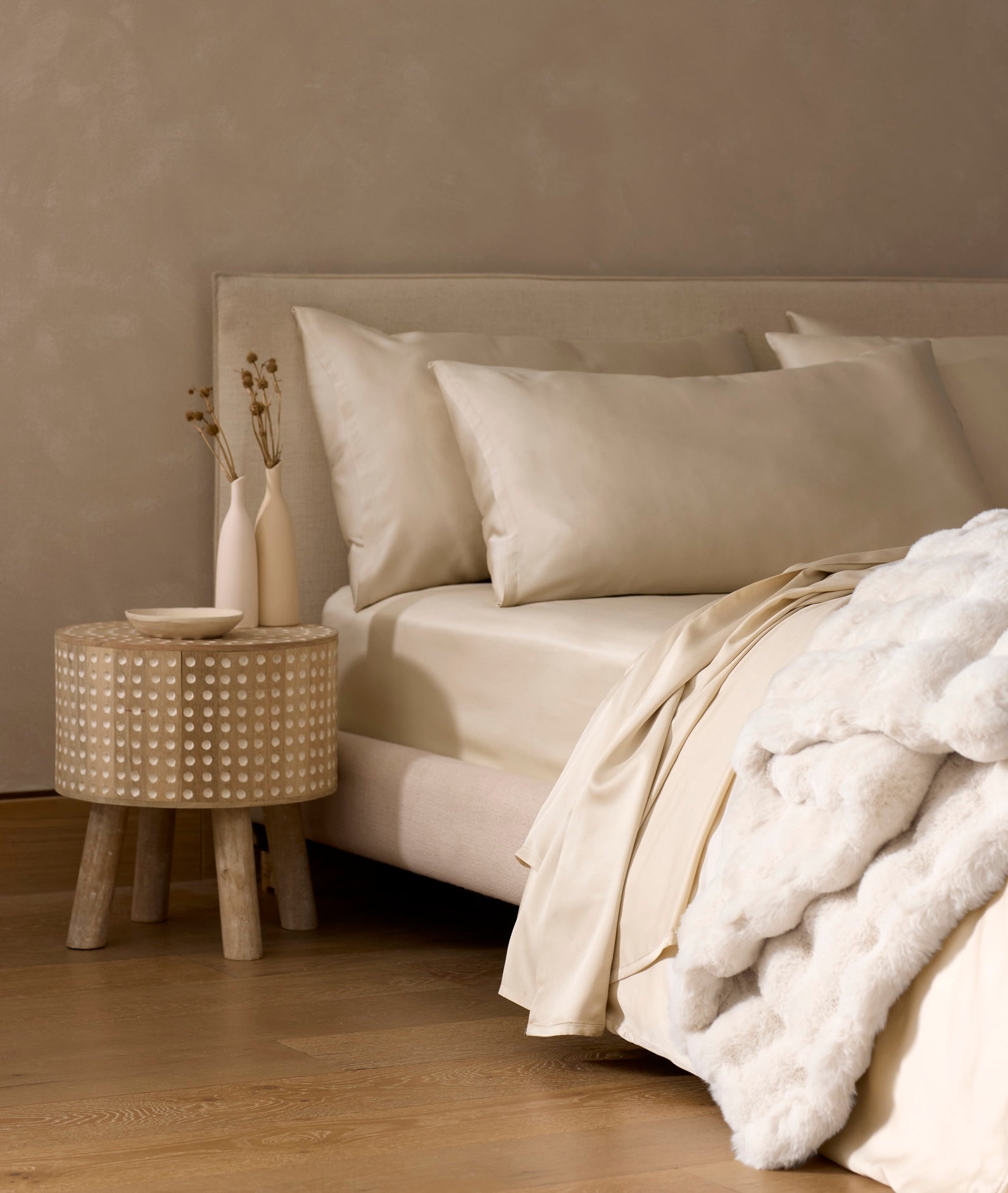 Bed and side table featuring Cozy Earth Bedding and Bubble Cuddle Blanket in neutral colors