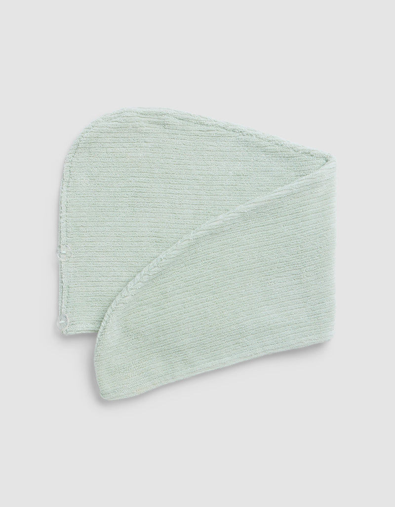 A Cozy Earth Ribbed Terry Hair Towel in light green is folded neatly against a plain white background.