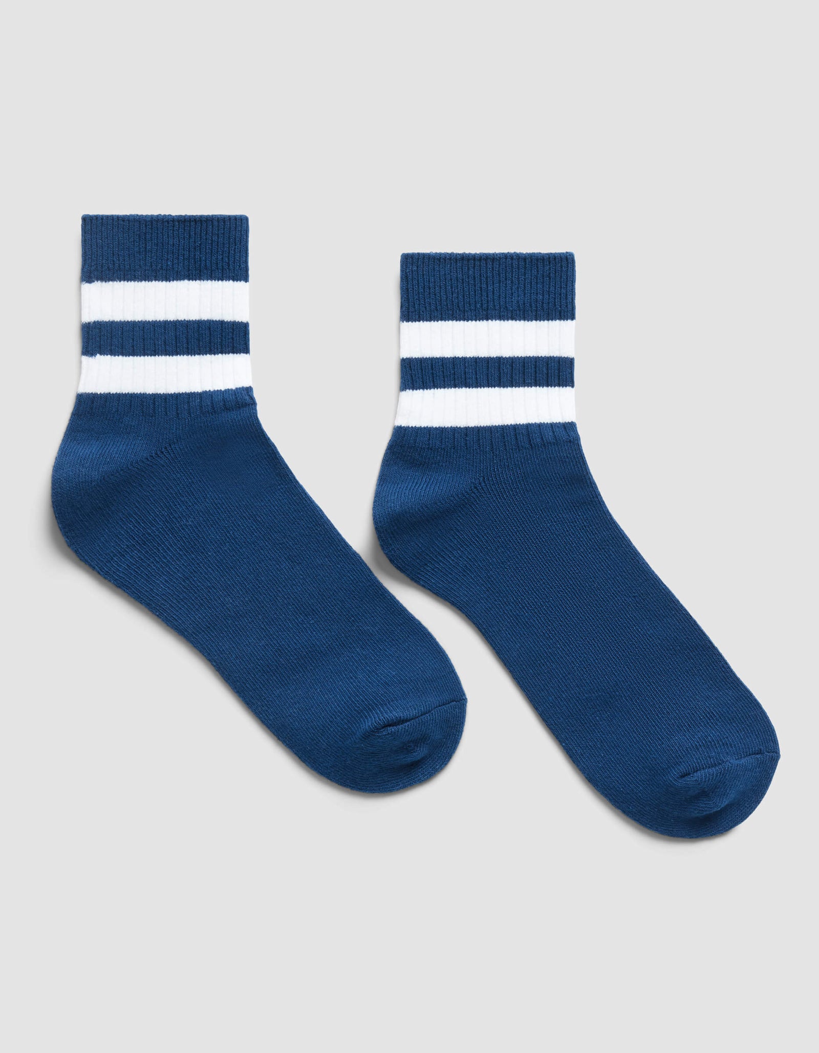 The Women's Sadie Sock by Cozy Earth is a blue ankle sock featuring two white stripes around the top, shown on a light grey background.
