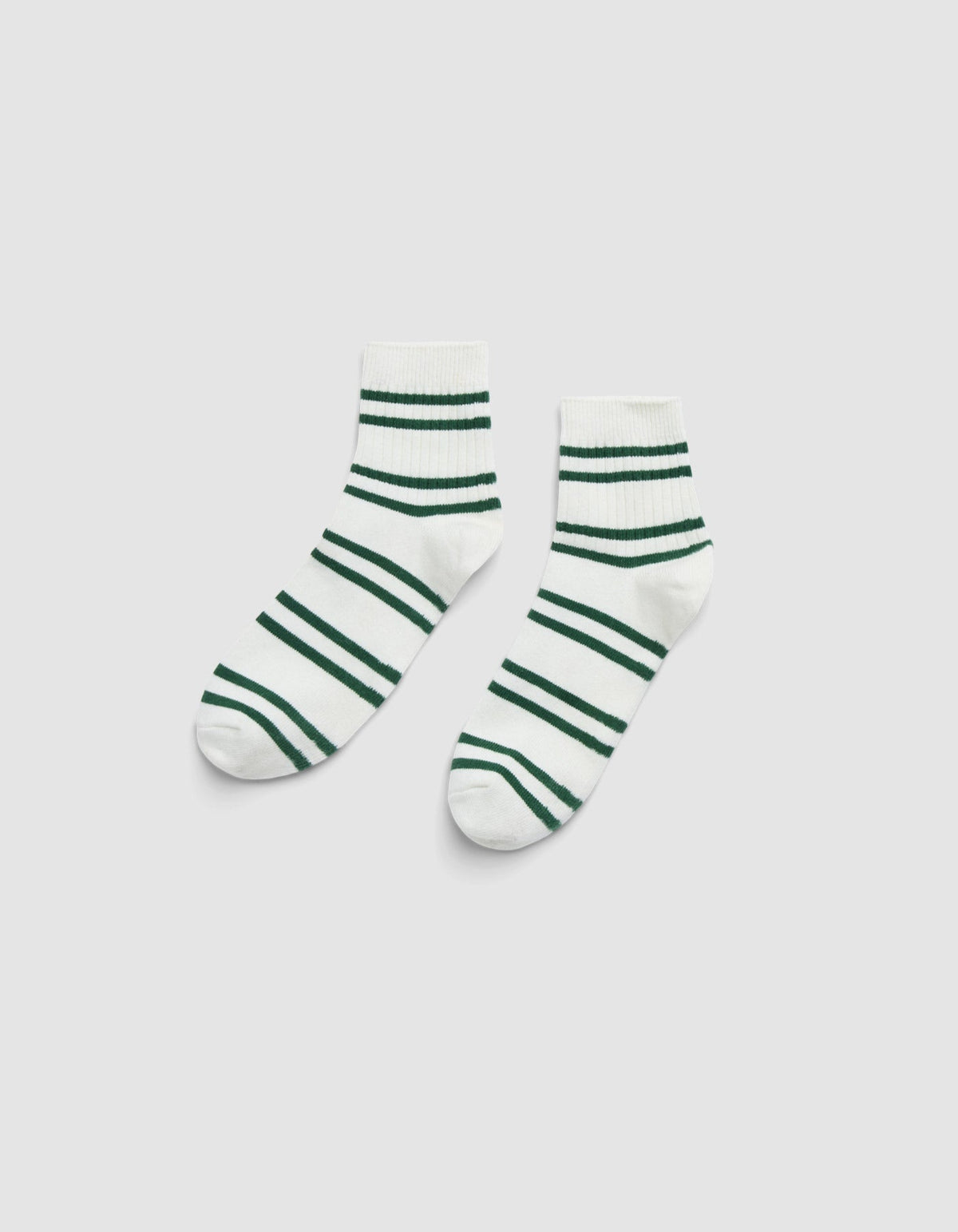 The Women's Sadie Sock by Cozy Earth—a pair of white ankle socks with green horizontal stripes—is displayed side by side on a light gray background. 