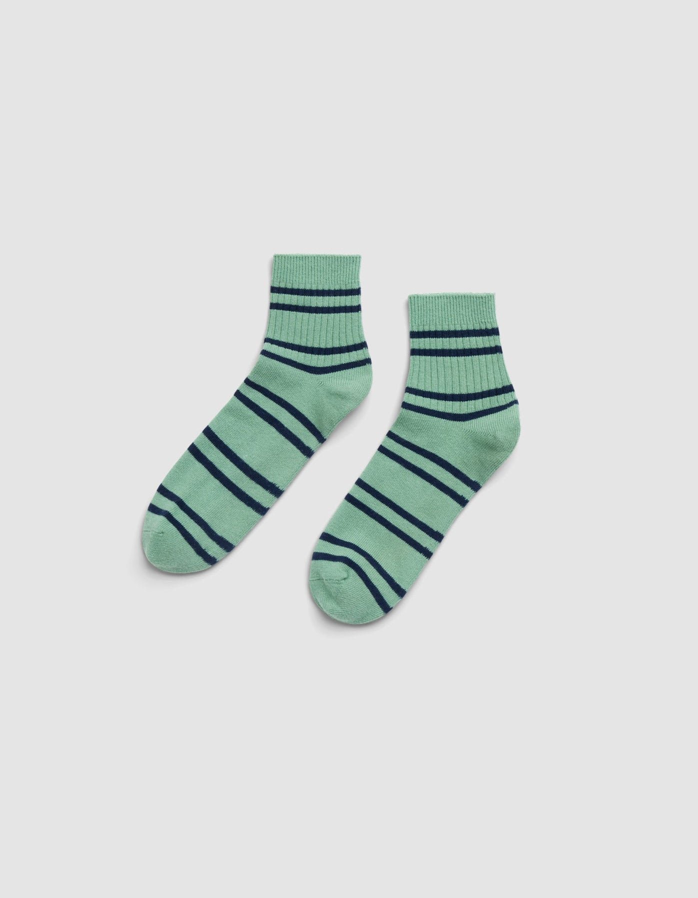 A pair of Cozy Earth Women's Sadie Socks in green with navy blue and dark green stripes, displayed side by side on a light gray background. 