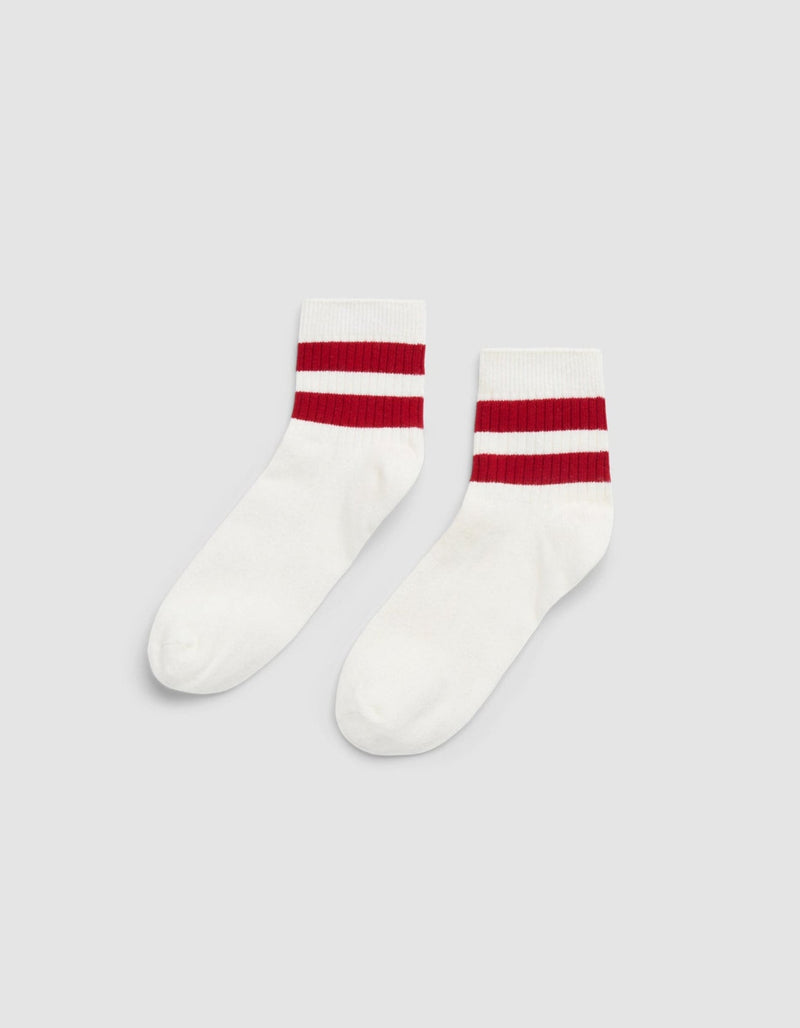 The Women's Sadie Sock by Cozy Earth is a white crew sock with two thick red stripes near the top, shown on a plain light gray background.
