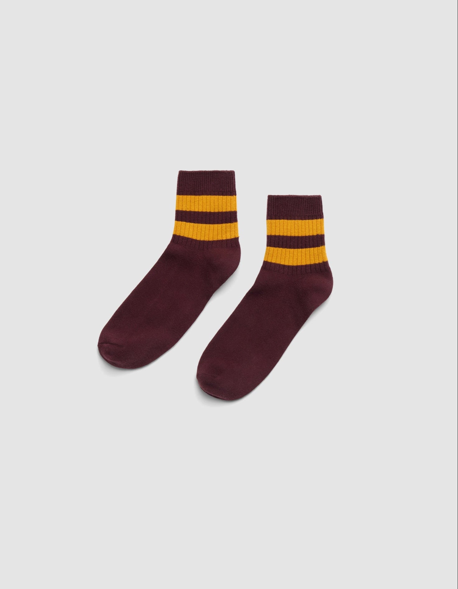 The Women's Sadie Sock by Cozy Earth is shown in maroon with two thick yellow stripes near the top, set against a plain white background. |Color:Burgundy/Goldenrod
