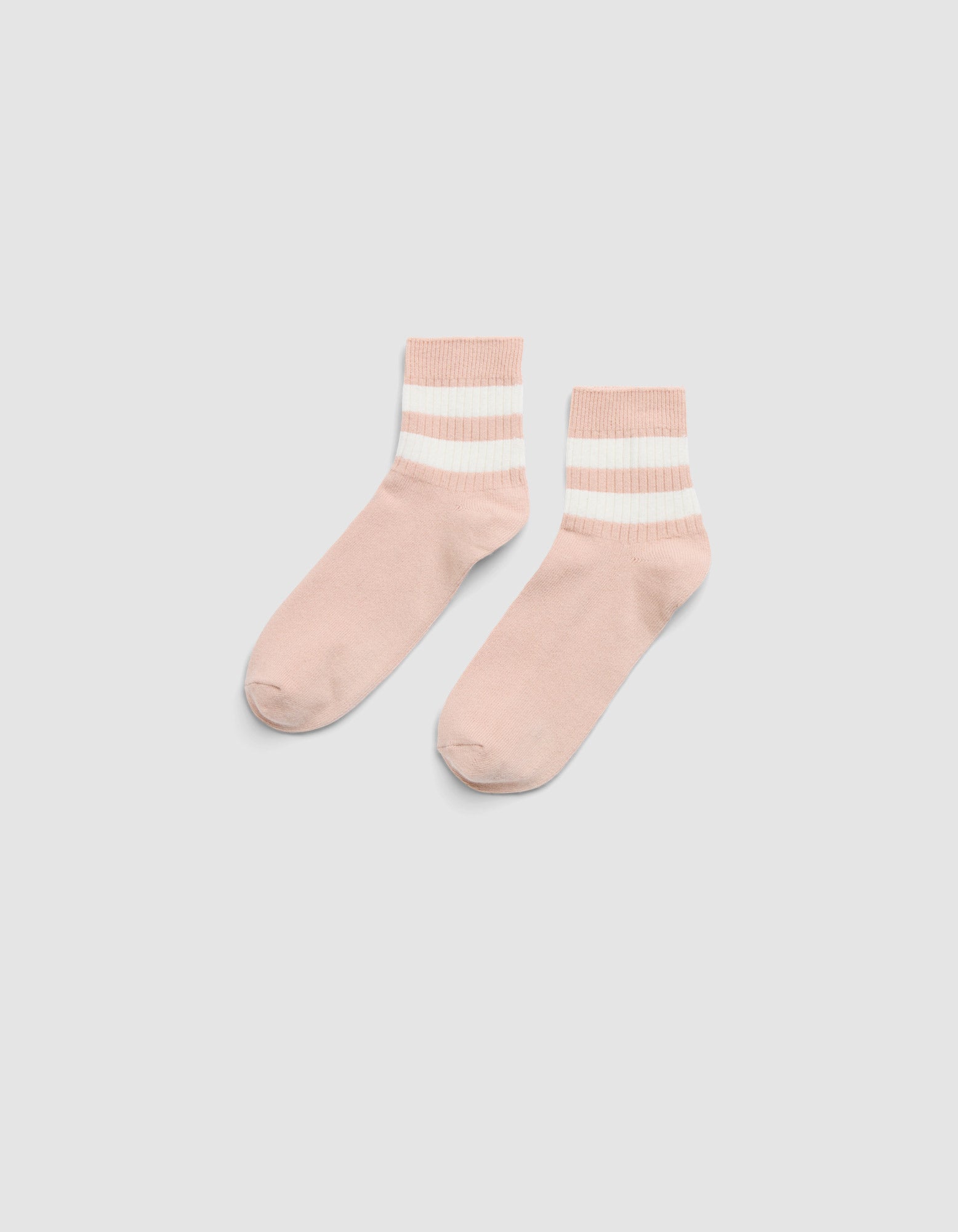 The Women's Sadie Sock by Cozy Earth features light pink fabric with two white and one beige horizontal stripes near the cuffs, shown on a light gray background.  |Color:Dusty Rose/Bone