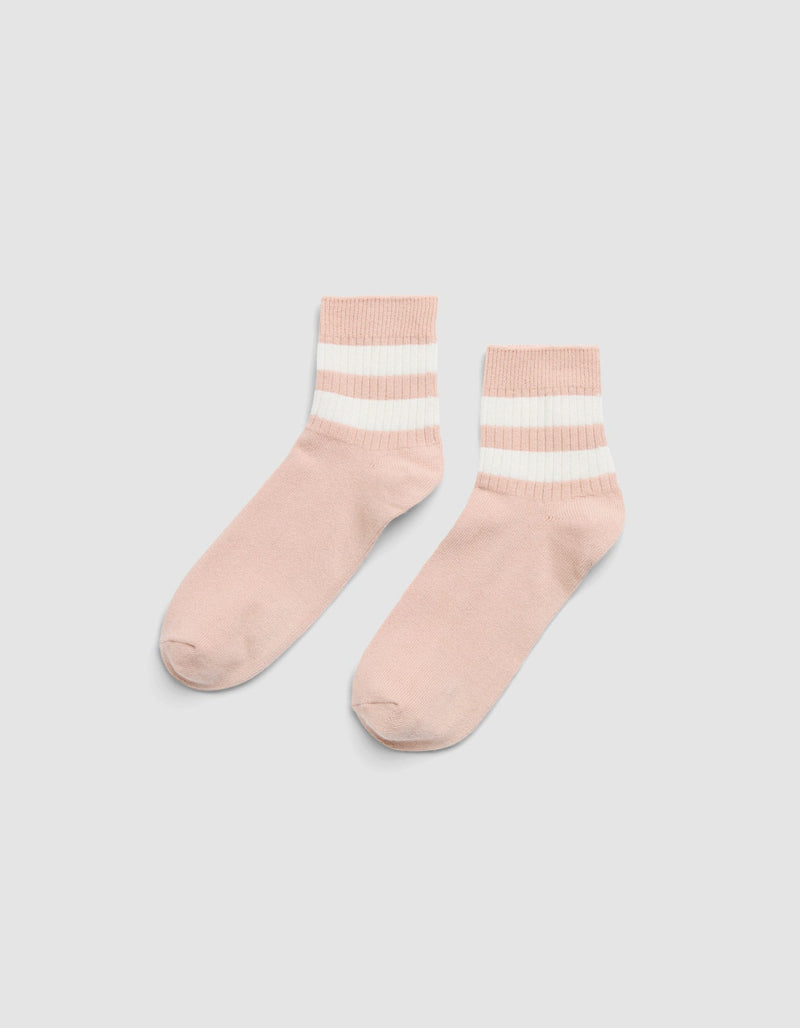 The Women's Sadie Sock by Cozy Earth features light pink fabric with two white and one beige horizontal stripes near the cuffs, shown on a light gray background.