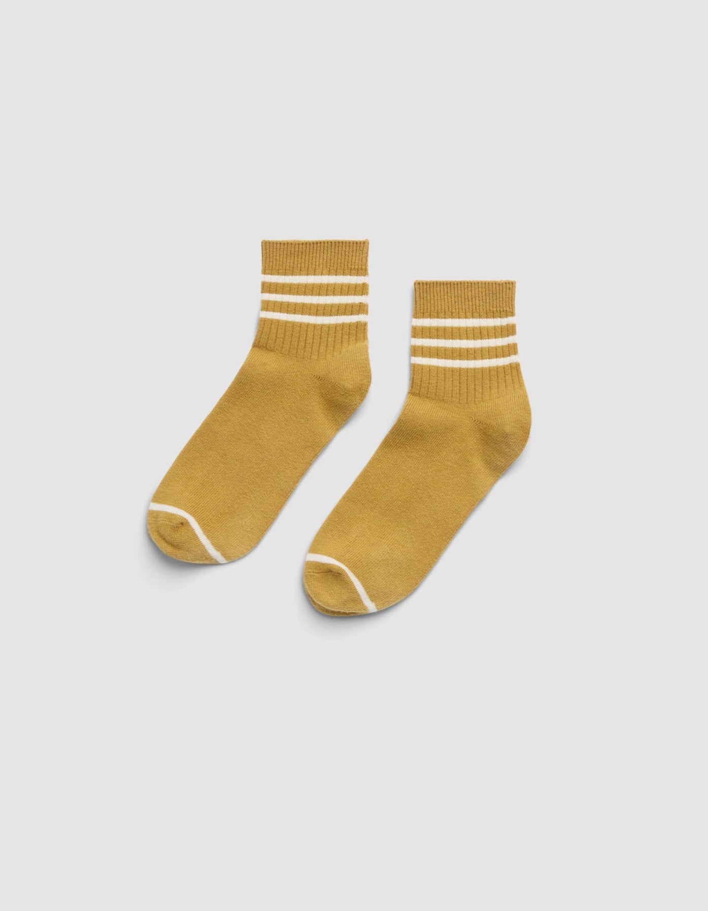 The Cozy Earth Women's Sadie Sock is a mustard yellow ankle sock with two white stripes near the top and white trim at the toe and heel, shown on a light gray background. |Color:Dijon/Alabaster
