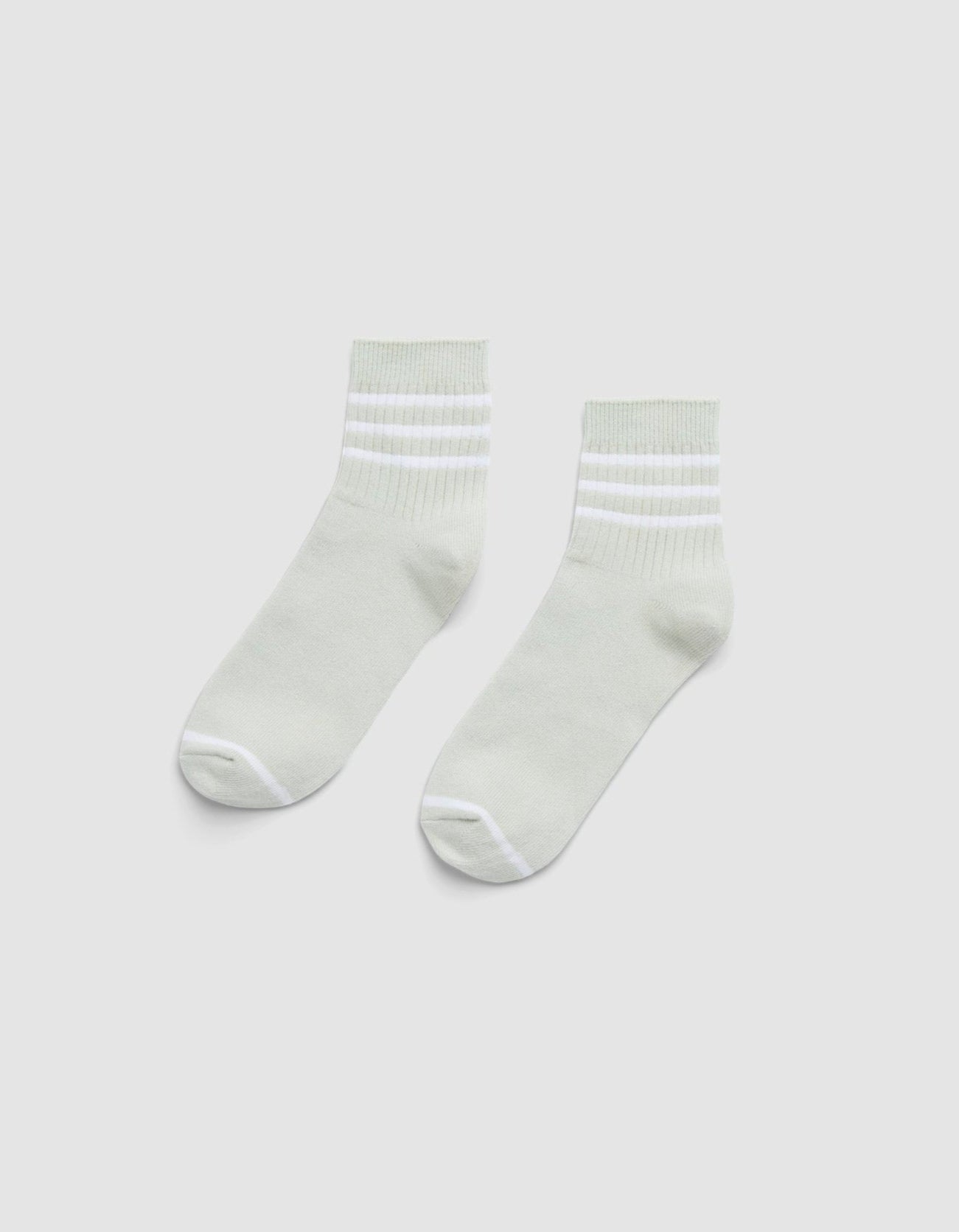 The Cozy Earth Women's Sadie Sock is a pair of light gray ankle socks with white toes, heels, and two white stripes near the cuffs, shown laid flat on a plain white background. 