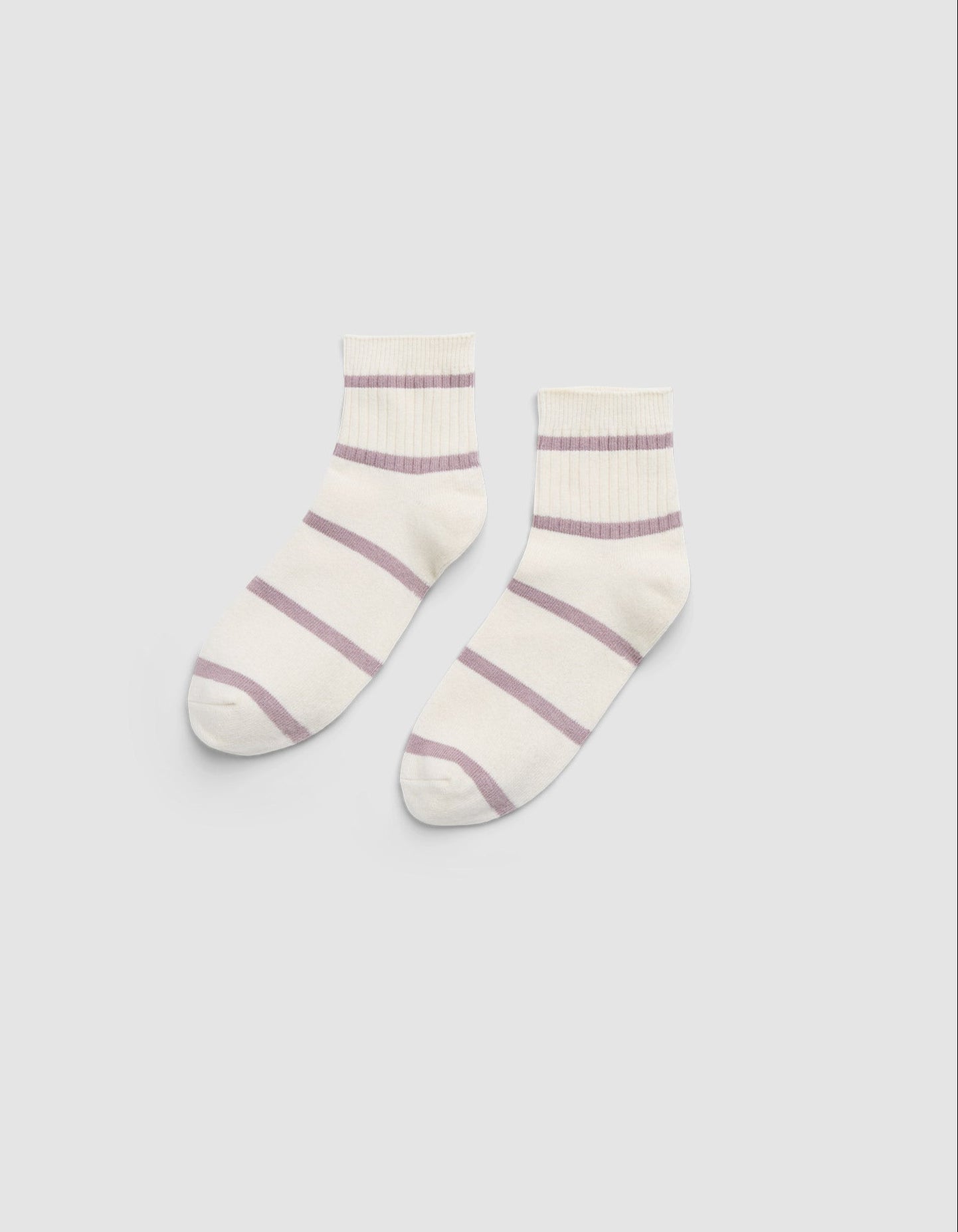 The Women's Sadie Sock by Cozy Earth is a pair of white ankle socks featuring light purple horizontal stripes and ribbed cuffs, displayed flat on a light gray background. |Color:Parchment/Dusty Orchid