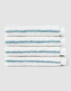 Five Striped Luxe Washcloths by Cozy Earth, white with light blue stripes, are neatly stacked against a plain light gray background. |Color:Brook Stripe