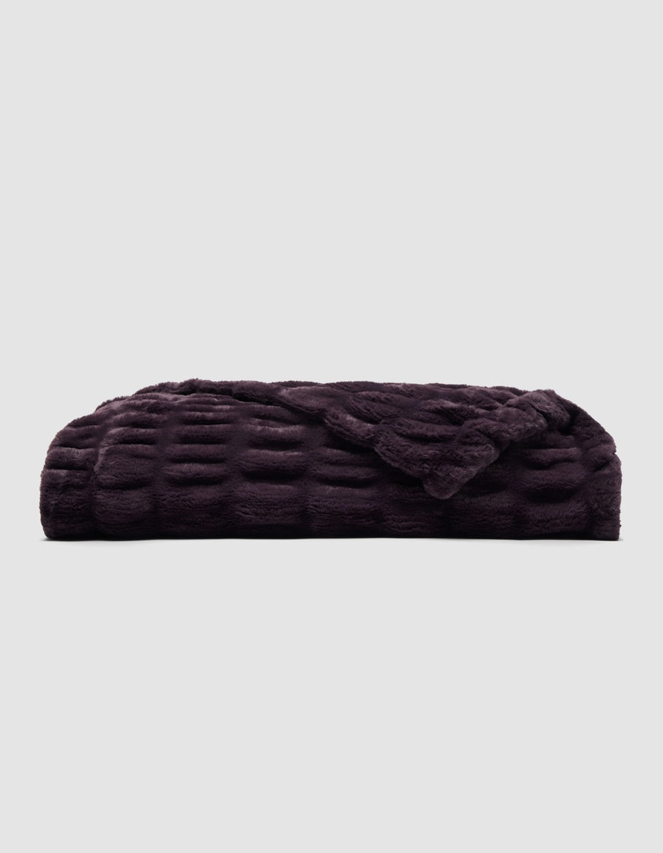 Folded plum-colored Snuggle Cuddle Blanket with a textured, grid-like pattern.|Color:Plum