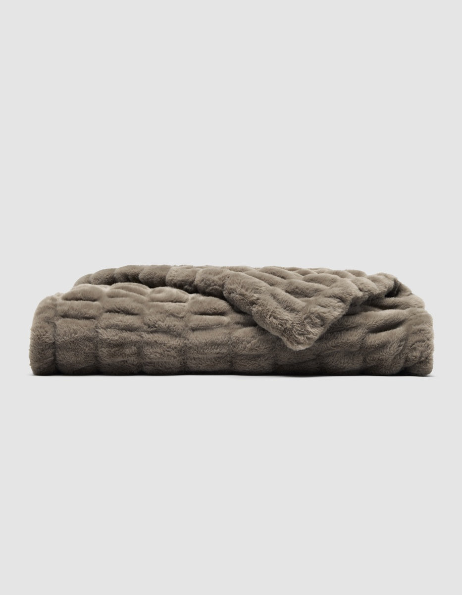 A folded, walnut-brown Snuggle Cuddle Blanket with a textured, plush surface.|Color:Walnut