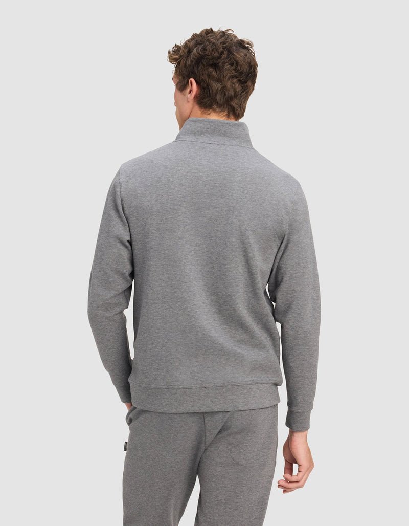 A man with curly brown hair, shown from the back against a light gray background, wears the Cozy Earth Men's StretchTech Quarter Zip in light gray.