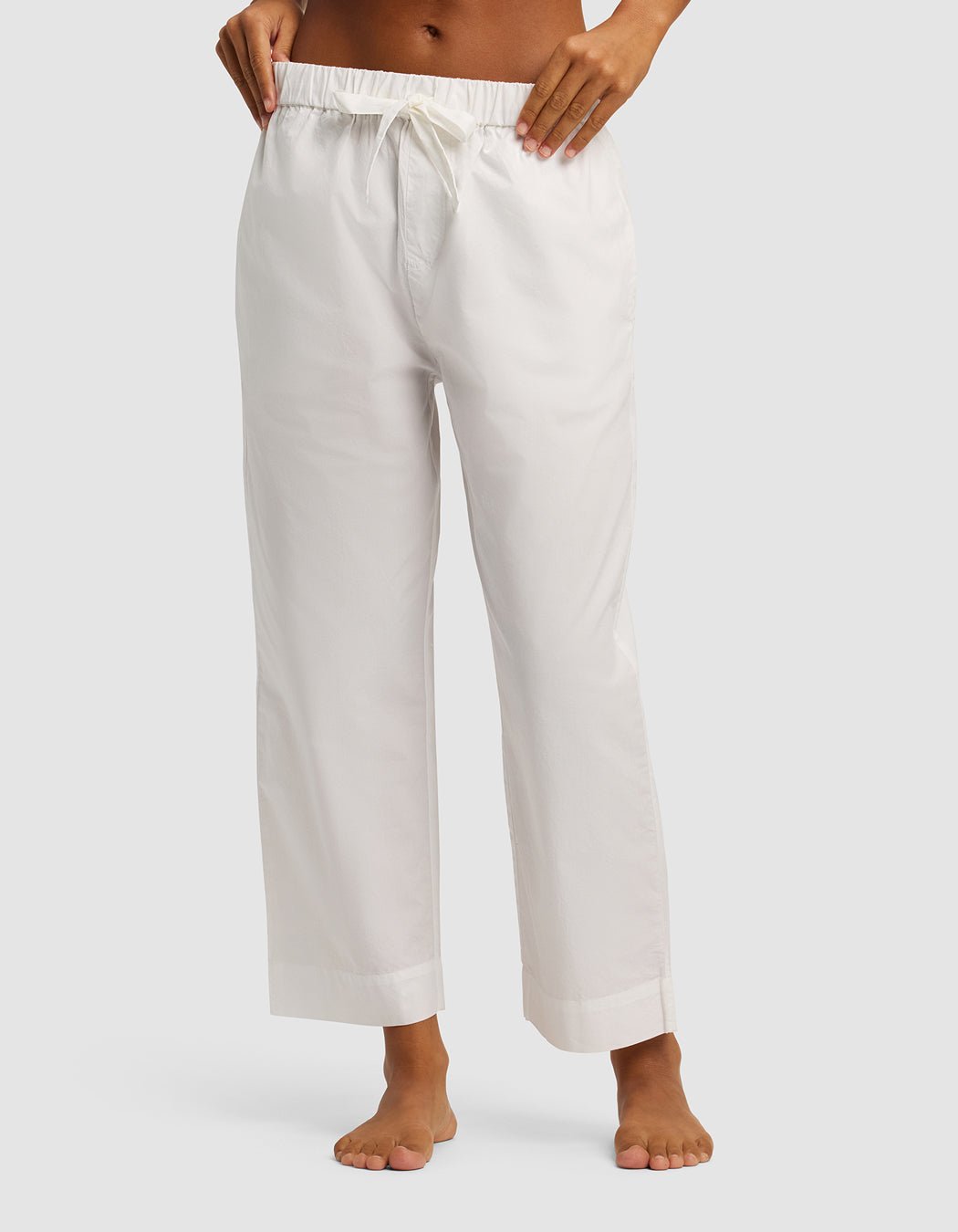 A person stands barefoot, wearing Cozy Earth's Women's Sutton Cropped Pajama Pant. Only the lower torso and legs are visible against a plain light background.