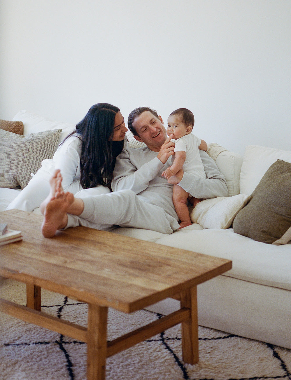 Family of three sitting on a couch in a living room