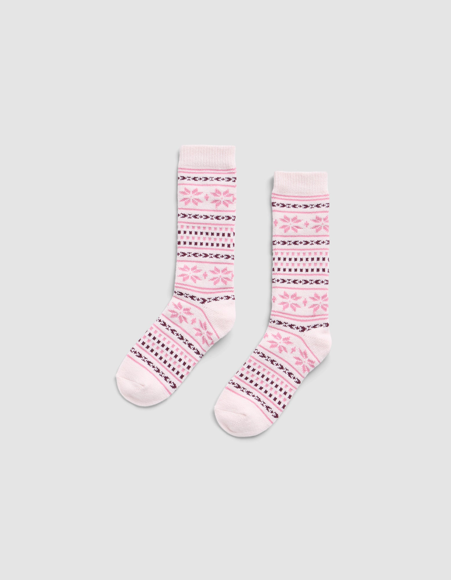 The Snowflake Plush Lounge Sock by Cozy Earth is a pair of pink crew socks with pink, purple, and white horizontal stripes and floral motifs, displayed on a light gray background.