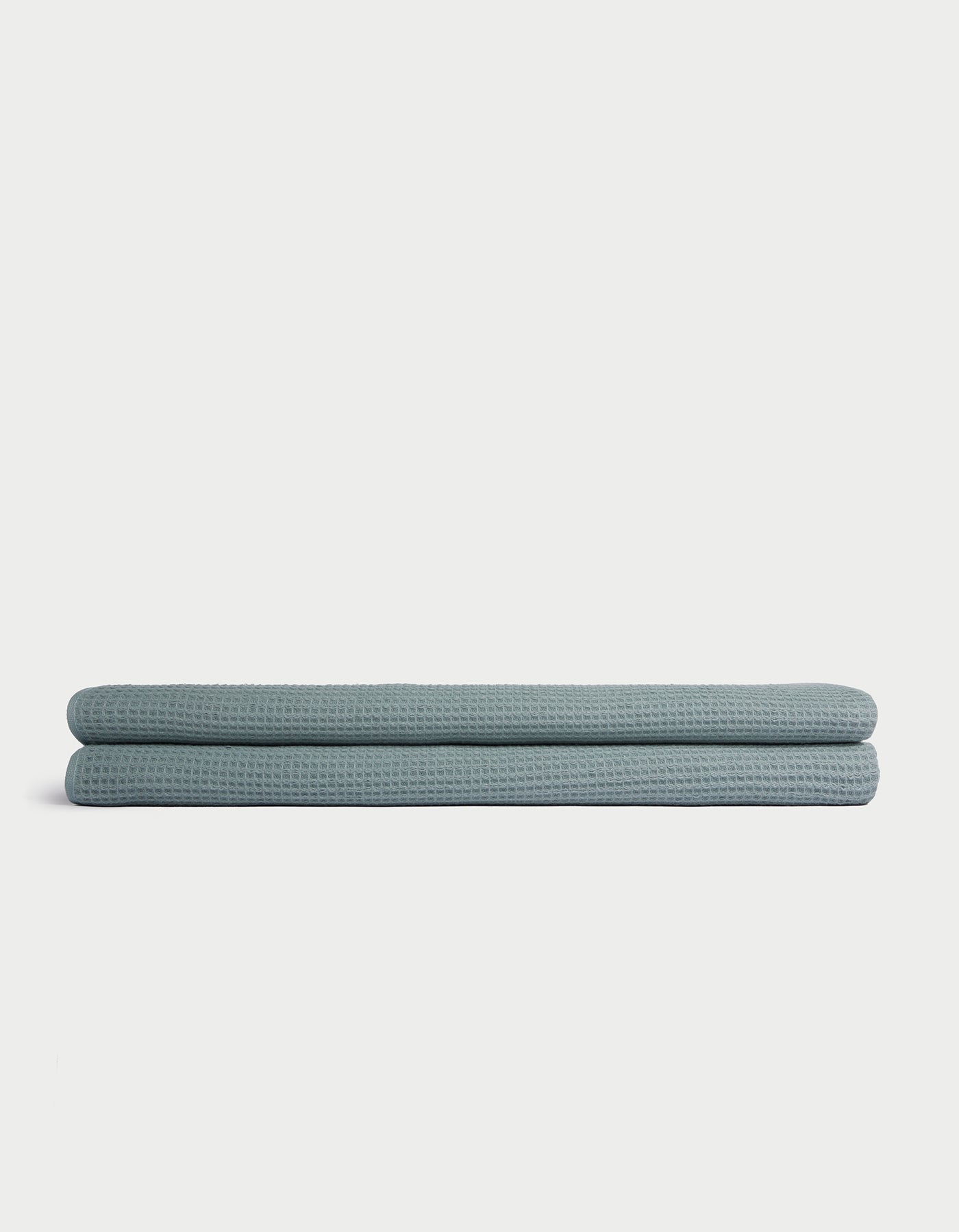 A folded light blue Cozy Earth Waffle Bath Sheet is displayed on a plain white background. 
