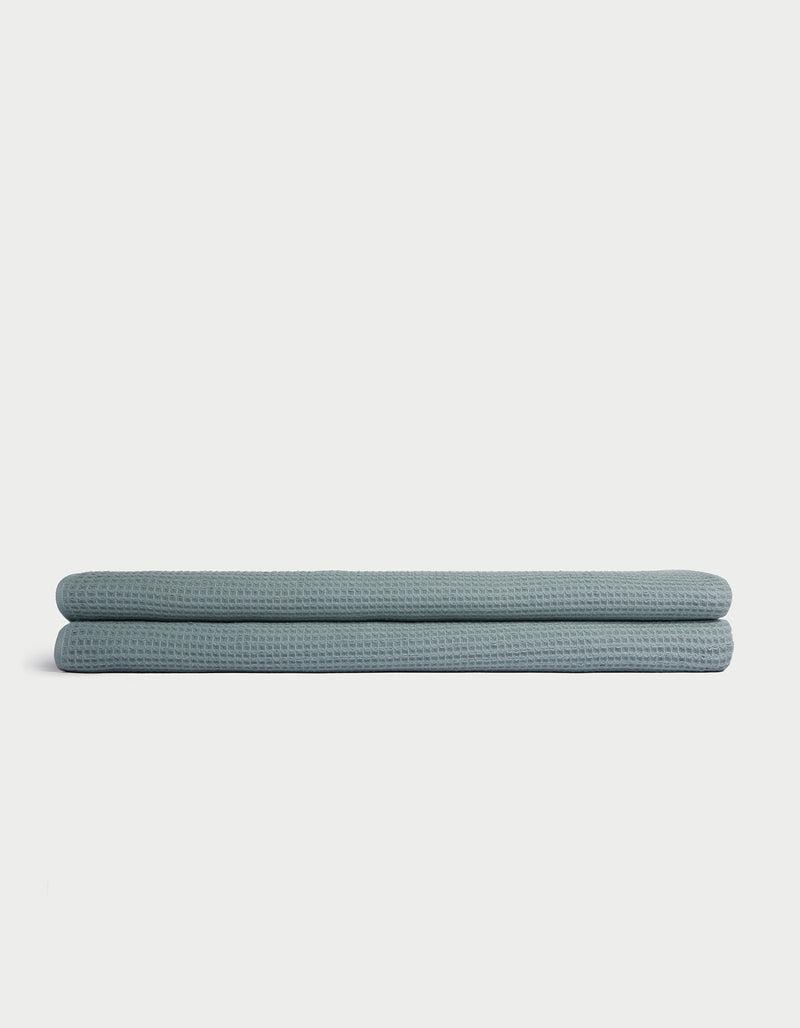 A folded light blue Cozy Earth Waffle Bath Sheet is displayed on a plain white background.