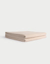 A neatly folded, light beige Cozy Earth Waffle Bath Towel lies on a white background. |Color:Birch
